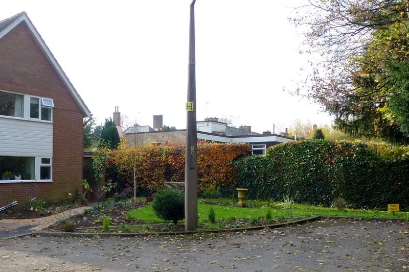 The same front garden cleared, with a lawn, new edged beds and a trimmed hedge